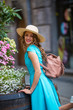© Елена Кравчук - Girl smiling looking camera, in blue dress, hat, outdoor, beautiful city flowers