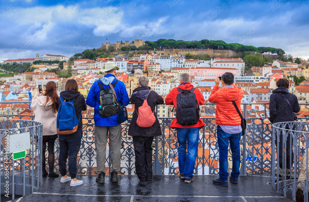 Group of tourists watching the cityscape of Lisbon and taking pictures to Sao Jorge castle in Portugal - obrazy, fototapety, plakaty 