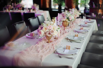 wedding table setting with flower vases and seating for guests