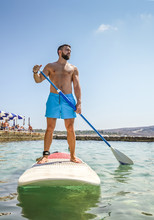 Man Paddling On Sup Board In Blue Sea. Beginner Paddler Summer Active Vacation And Water Sport Concept