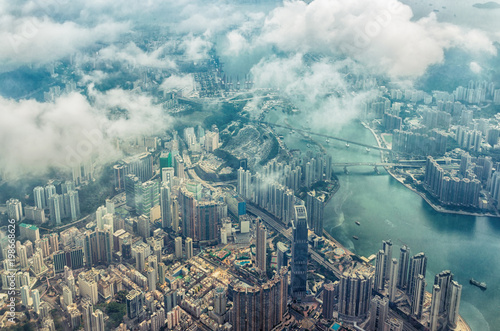 Bird\'s eye or aerial view through the clouds to large metropolis city of Hong Kong.