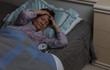 senior woman with headache during nighttime while in bed