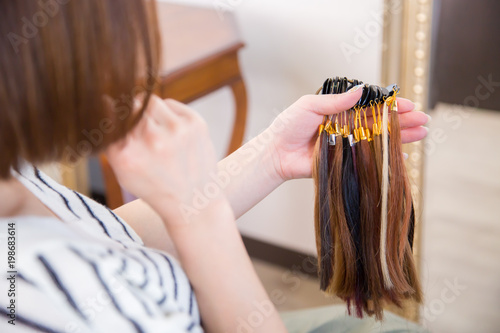 ヘアカラーサンプルを見る女性 Adobe Stock でこのストック画像を