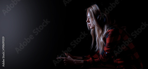 Foto  girl gamer in headphones and with a joystick in her hands playing network games