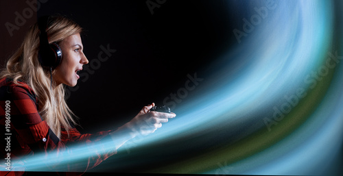 Foto girl gamer in headphones and with a joystick in her hands playing network games