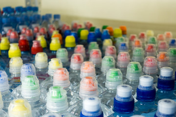 Wall Mural - Drinking water, multi-colored plastic cap. Bottle caps on the market close up.