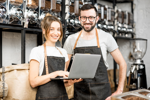 Cuadros en Lienzo Coffee store owners or managers working with laptop standing at the counter of t