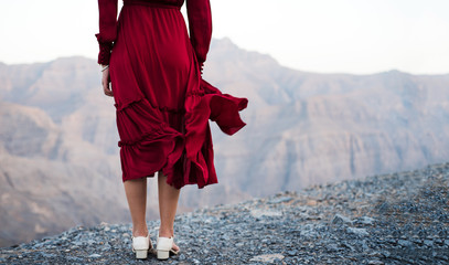 Wall Mural - Fashionable girl in red dress on a desert mountain top