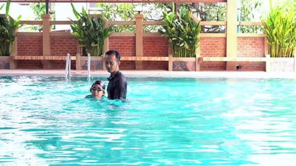 Wall Mural - Father teaches daughter to swim