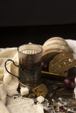 Fototapeta Na sufit - Conceptual still life of pieces of bread, onion bulb, a glass of tea and refined sugar, on an ancient wooden table lying on a wooden tray, a piece of cloth