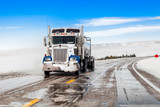 Fototapeta  - big truck drives on a snowy road