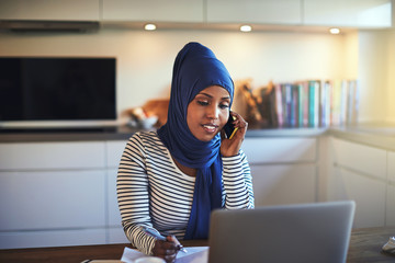 Wall Mural - Young Arabic female entrepreneur working at her kitchen table