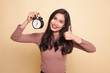 Young Asian woman show thumbs up with a clock.