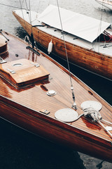 beautiful classic wooden boats docked at the sea port on a still dark water. glossy coating of varni