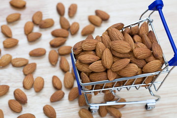 Wall Mural - Almonds in shopping cart on wooden table.