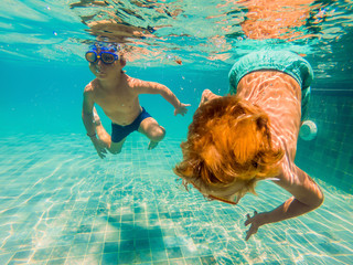 two children diving in masks underwater in pool