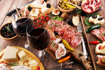 Italian antipasti wine snacks set. Cheese variety, Mediterranean olives, pickles, Prosciutto di Parma and salami