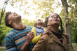 © Mladen - Happy African American parents enjoying with daughter in park and looking up.