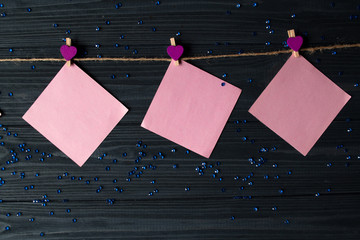 Wall Mural - Pink memo sheets fastened with a decorative pin on a dark blue wooden board.