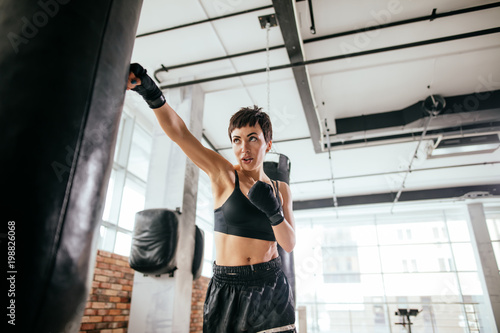 Fotomural close-up shot of kickboxing beautiful female at sport center
