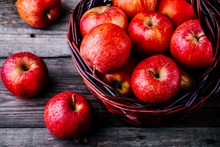 Red Ripe Apples In A Basket On A Wooden Background