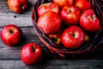 Wall Mural - red ripe apples in a basket on a wooden background