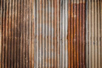 Rusty and corrugated iron metal construction site wall texture background with vignette.