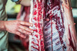 close up of the ribs and raw meat of a fresh killed pig hanging at the slaughterhouse 