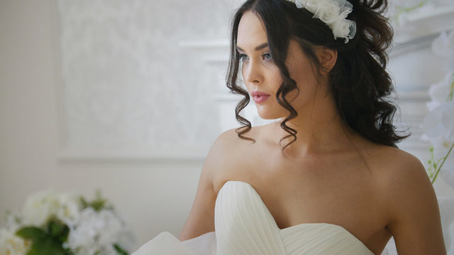 Attractive brunette bride in fashion wedding dress with professional makeup