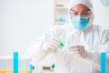 Young chemist student working in lab on chemicals