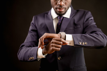 close up cropped image african male of setting of watch.live according to timetable. synchronize watches