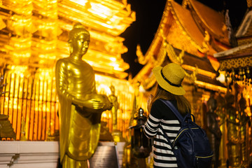 Wall Mural - Young woman traveler traveling to Wat Phra That Doi Suthep temple. This temple contains supreme examples of Lanna art in the old city center of Chiang Mai,Thailand.