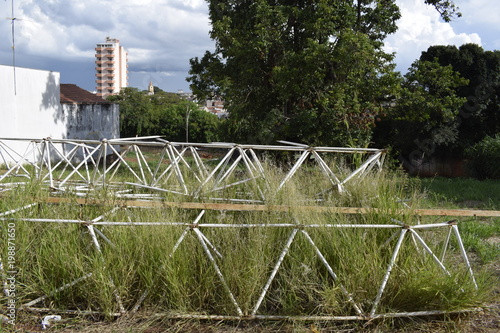 Fotografie, Obraz Estruturas metálicas treliçadas triangulares abandonada em lote vazio e cercado