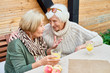© Seventyfour - Portrait of two senior women chatting happily  enjoying lunch outdoors, copy space
