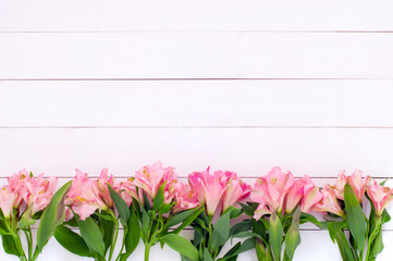 Wall Mural - Beautiful pink alstroemerias on a white woodent planks as a background (top flat view, copy space)