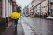 © phpetrunina14 - woman walk by side walk with yellow umbrella. rainy weather in old european city