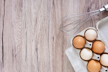 Fresh Raw Chicken Eggs In Carton Egg Box On Wooden Background. The Top View On Brown And White Eggs. Close-up View. The Main Ingredient For Many Dishes. Free Space For Inscriptions, Notes.
