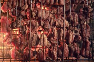 Wall Mural - Slices of chopped meat in a grate for cooking barbecue on charco