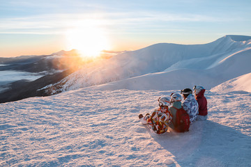 Poster - Group of friends enjoying the beauty of sunset at snowy ski resort. Winter vacation