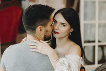Portrait Of A Couple Hugging While Woman Is Looking At The Camera.Adult Woman With Red Lips Hugging Her Man.