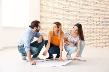 Poster - Real estate agent with trainee showing plan of apartment to client