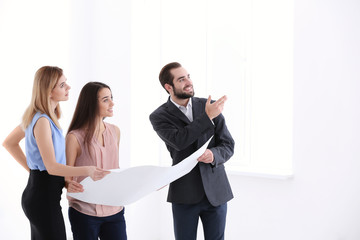 Poster - Real estate agent with trainee showing plan of apartment to client