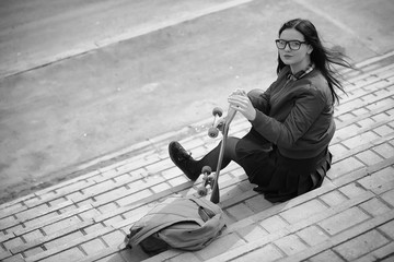 A young hipster girl is riding a skateboard. Girls girlfriends f