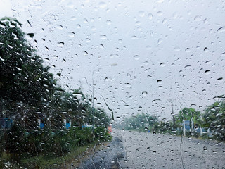 Heavy rain drop on the windows of car on the road.