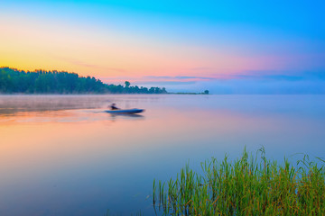 Wall Mural - Red canoe on a lake at sunrise