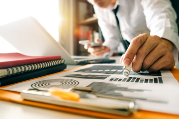  businessman hand working with laptop computer, tablet and smart phone in modern office  diagram at modernoffice in morning light 
