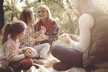 Wall Mural - Cheerful family having picnic together in park.