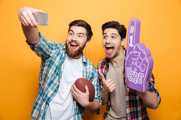 Wall Mural - Portrait of a two excited young men taking a selfie