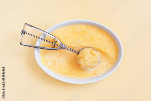 Zdjęcie XXL Domowej roboty sorbet cytrynowy w misce biały na stole żółty