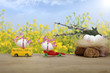 Jaja Wielkanocne na samochodach na tle błękitnego nieba i żółtych kwiatów w promieniach słońca.